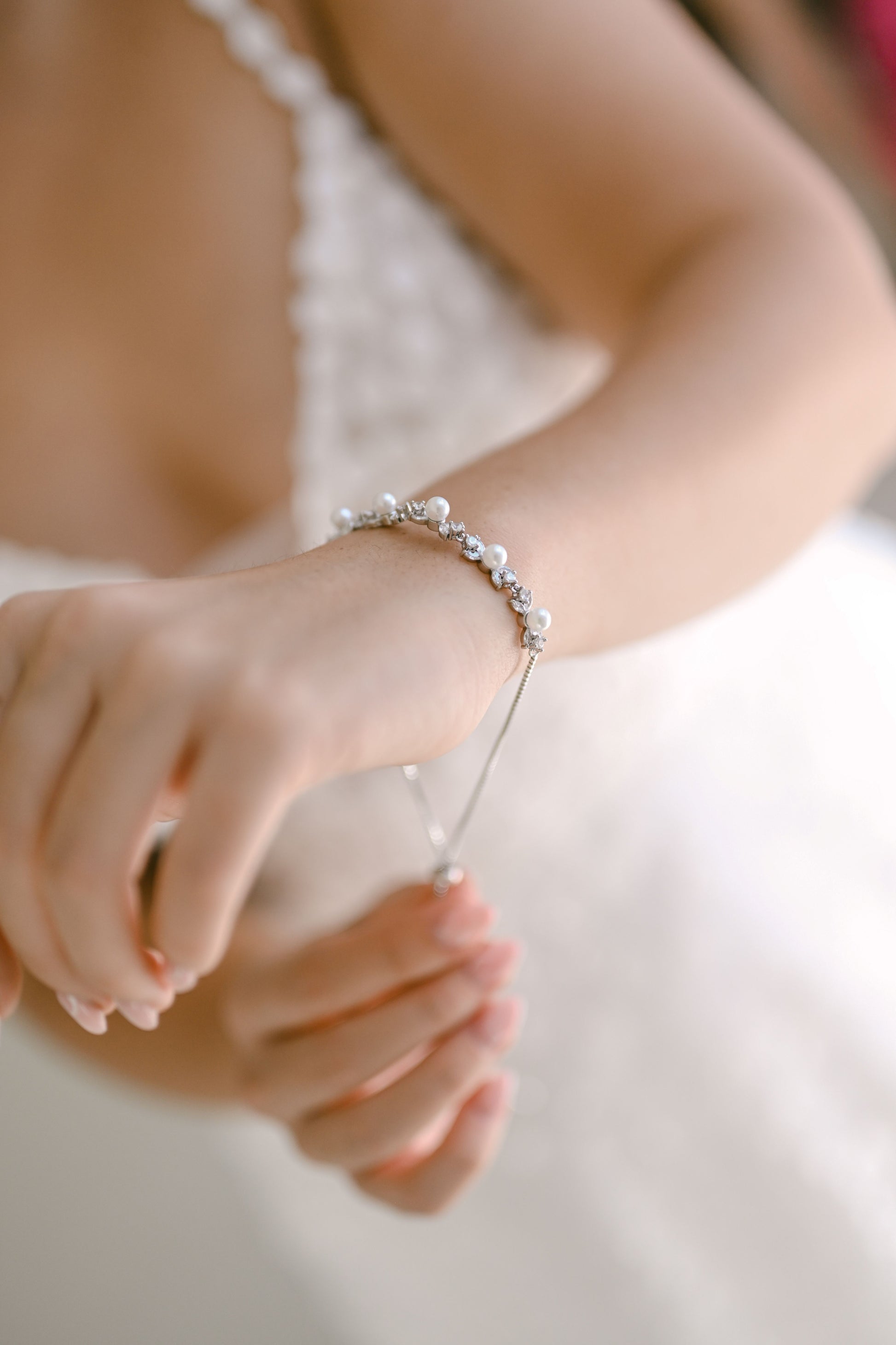 Bride wearing adjustable pearl and cubic zirconia bracelet