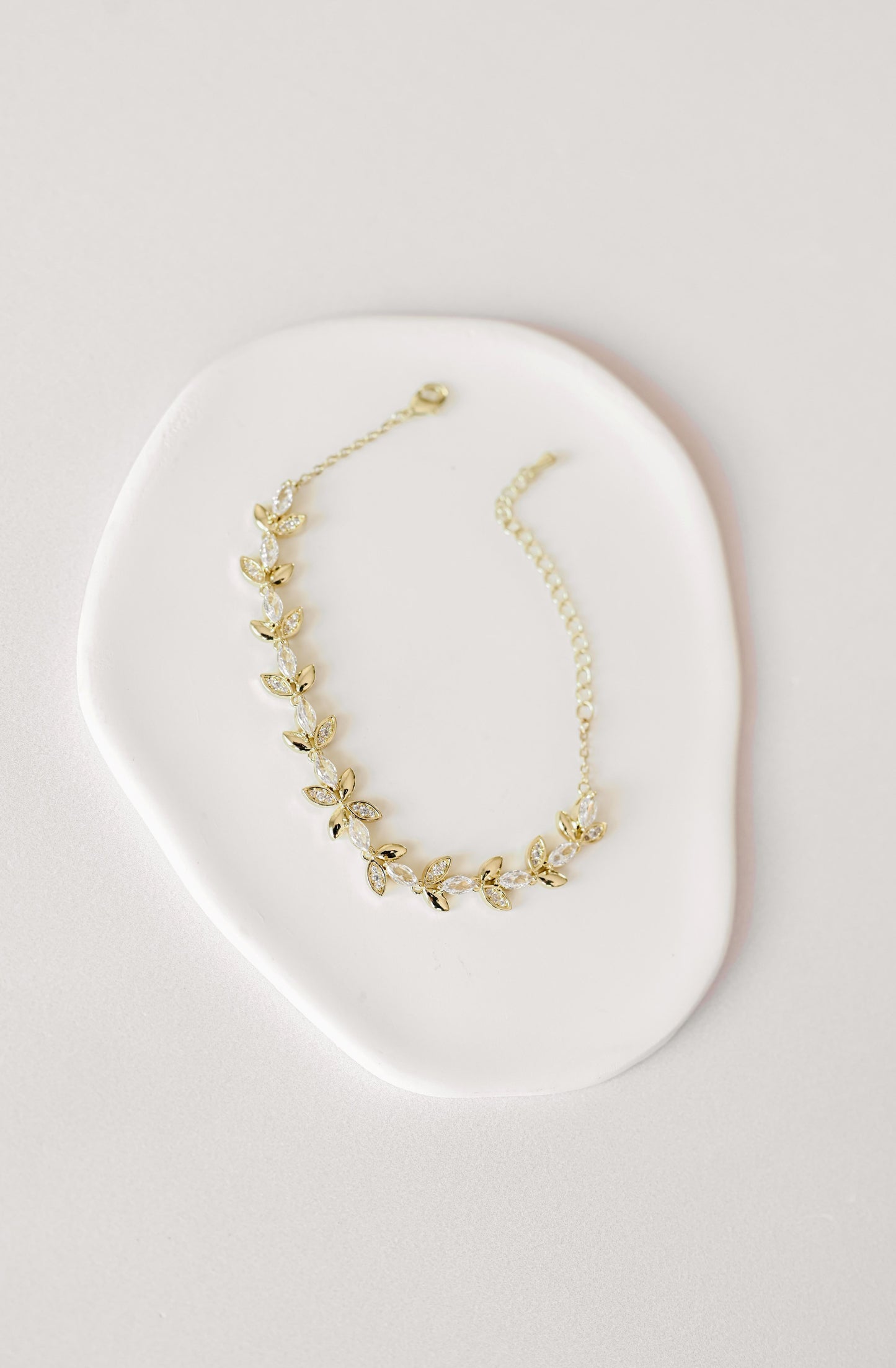 Gold bridal bracelet with cubic zirconia leaf design.
