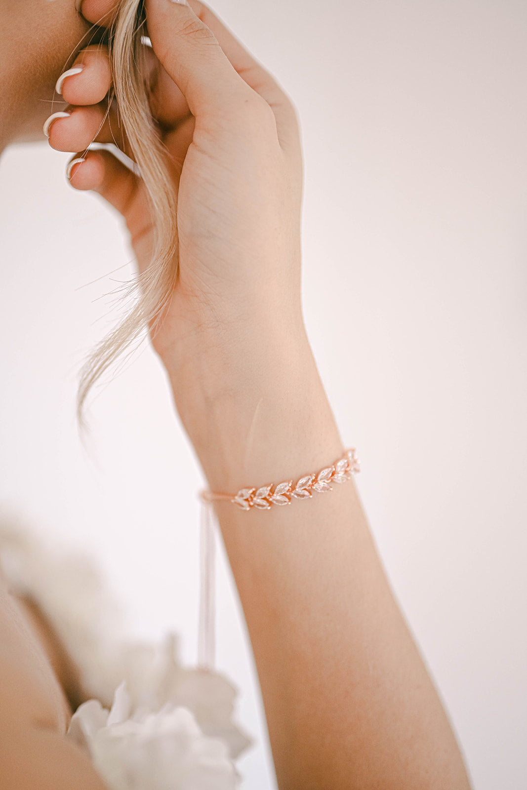 Bride wearing a rose gold leaf design bracelet with cubic zirconia
