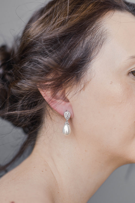 Bride wearing silver earring with cubic zirconia and teardrop pearl