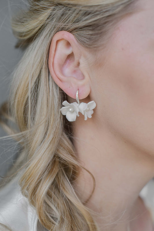 Bride wearing earrings with two porcelain flowers and fresh water pearls