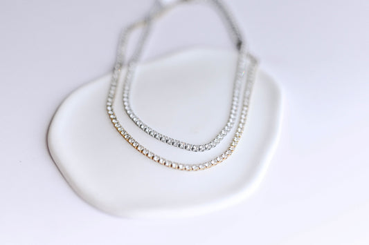 Stainless steel, 18K gold PVD plated necklace with 3mm cubic zirconia. Water and tarnish proof.