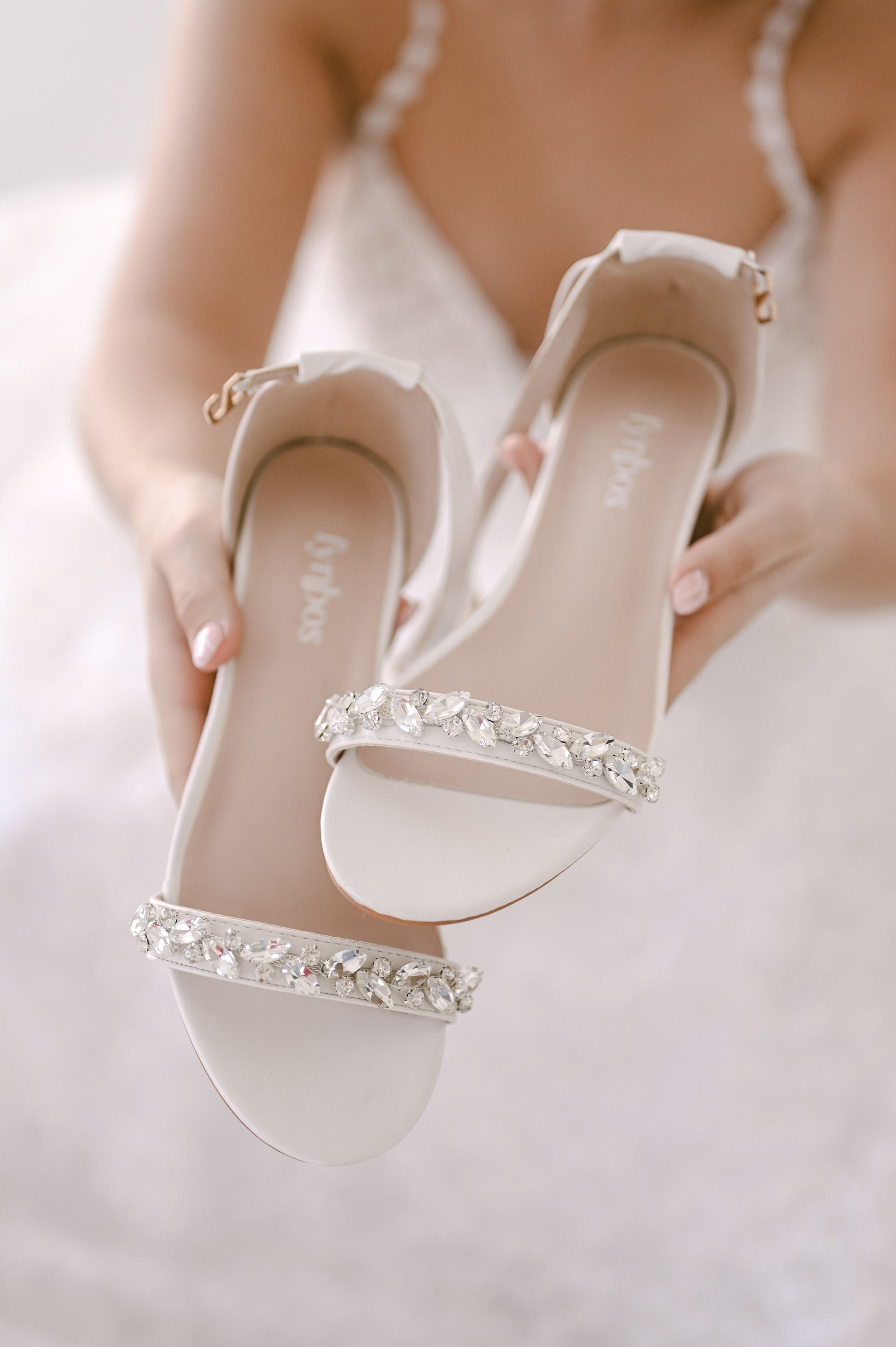 Ivory bridal shoe with open toe and block heel. Rhinestone embellishment on toe strap
