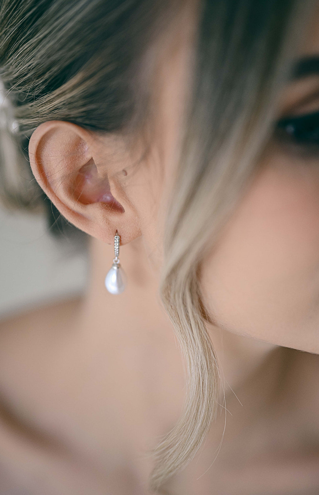Bride wearing silver hoop earring with cubic zirconia and a faux pearl