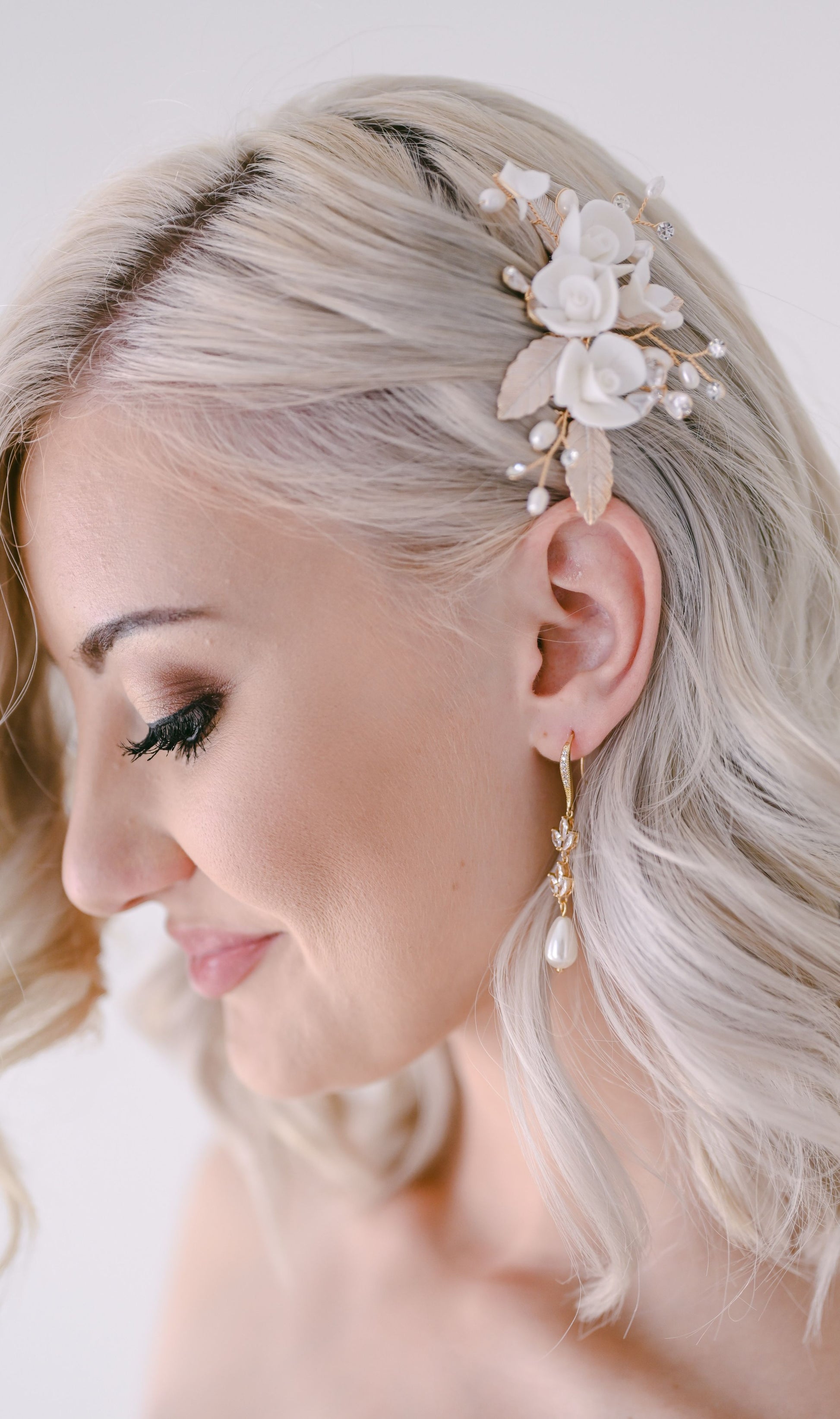 Bride wearing rose gold decorative air piece with porcelain flowers and leaf detail