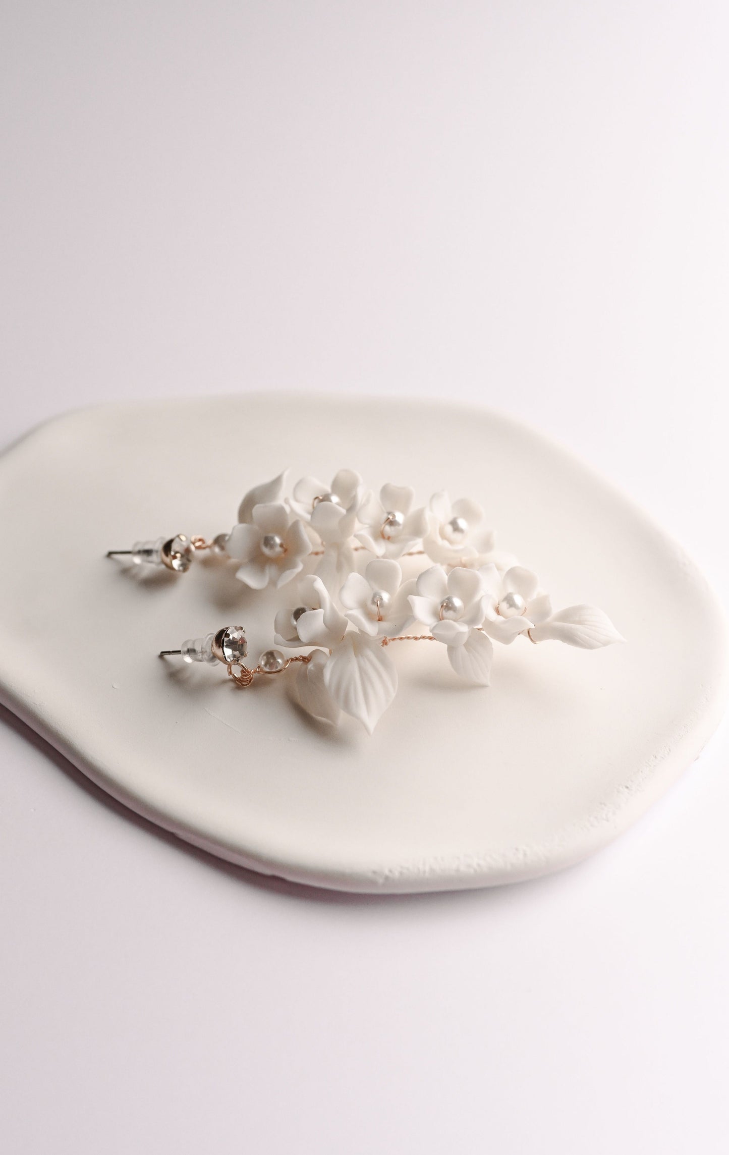 Gold bridal earring with a cluster of porcelain flowers