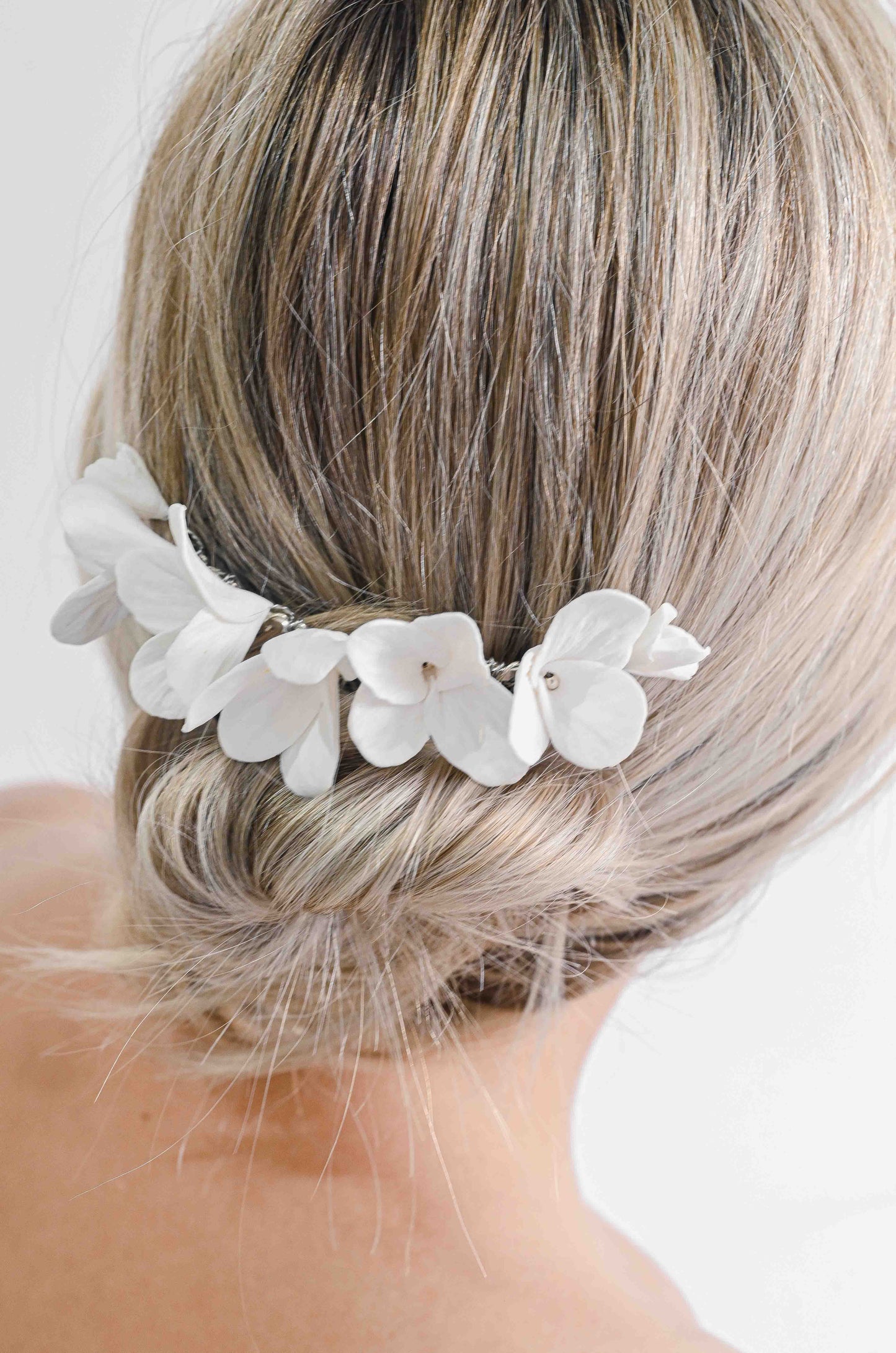 Bride wearing a bridal hair comb with handmade clay flowers
