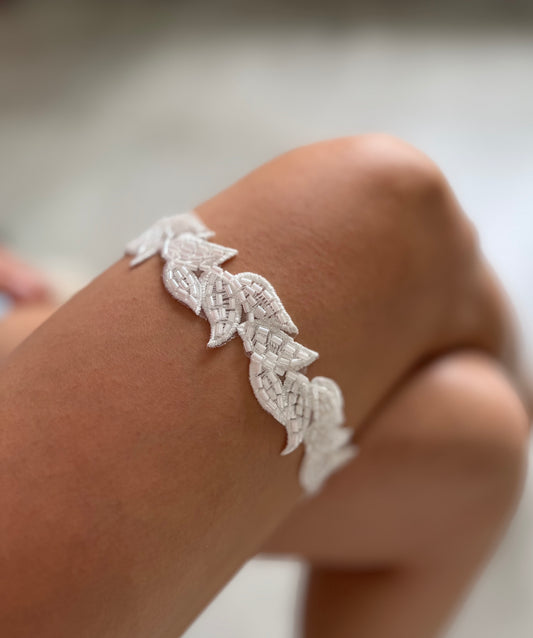 Bride wearing garter with beaded leaf lace design