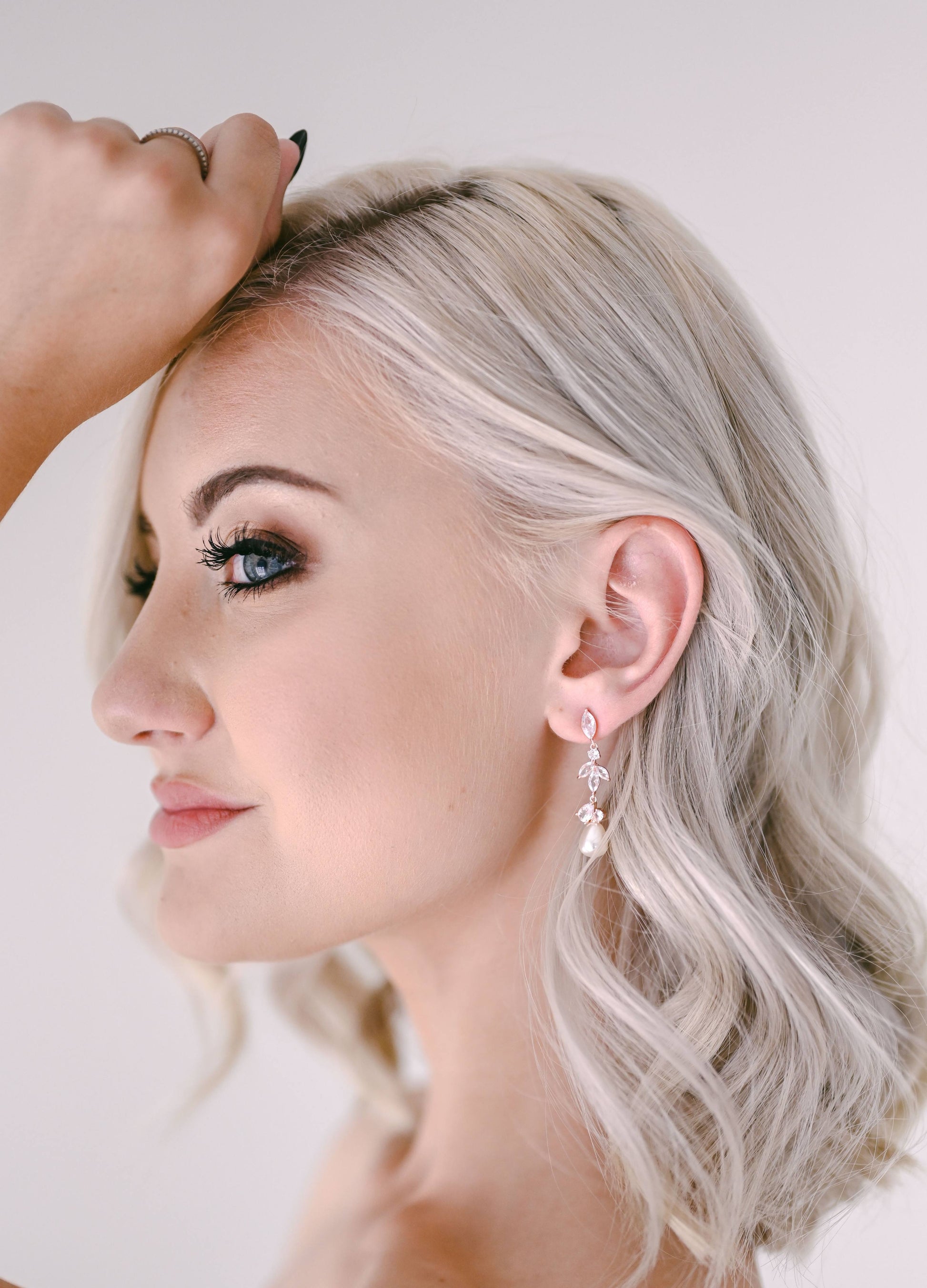 Bride wearing drop earring with cubic zirconia and pearl detail
