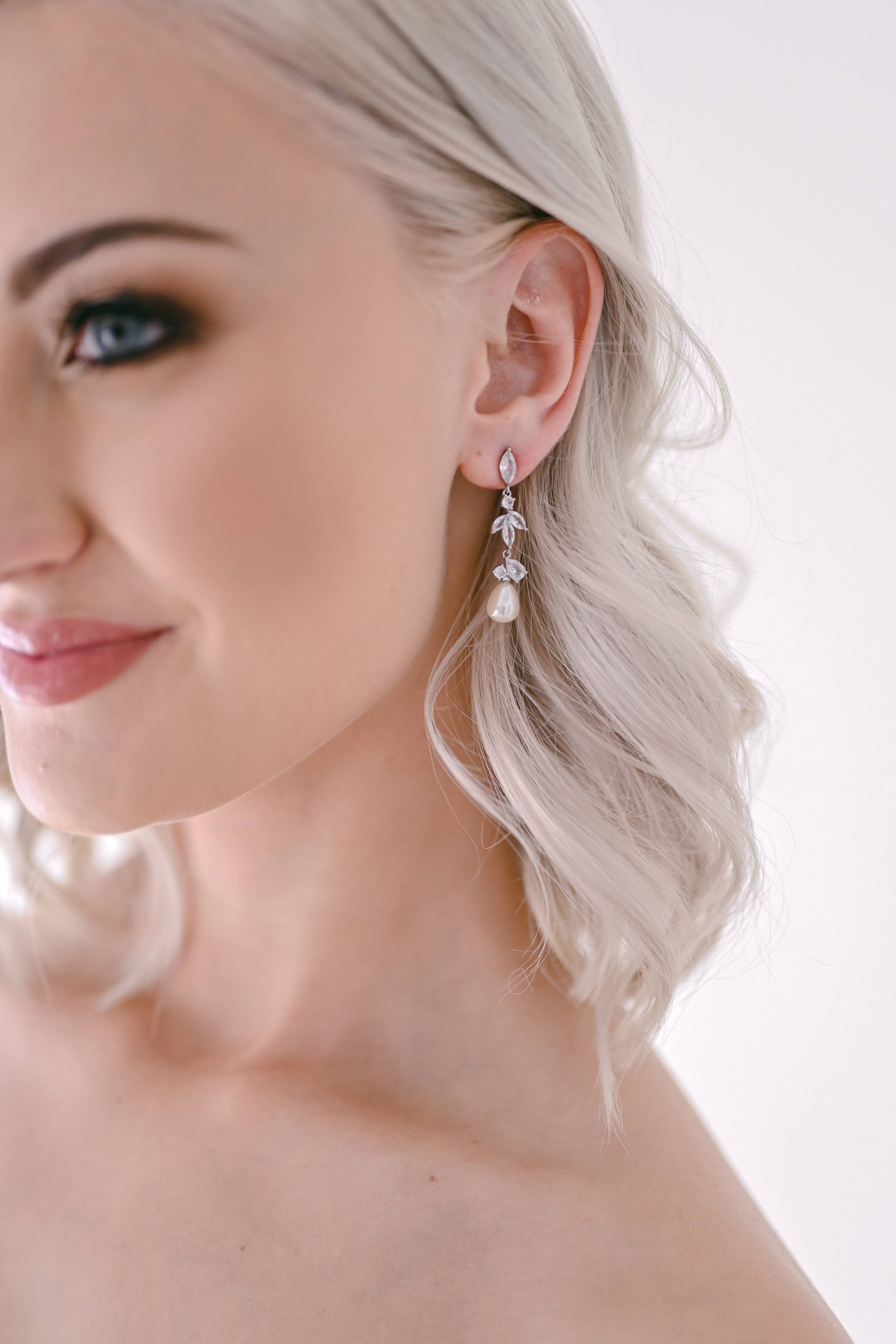 Bride wearing drop earring with cubic zirconia and pearl detail