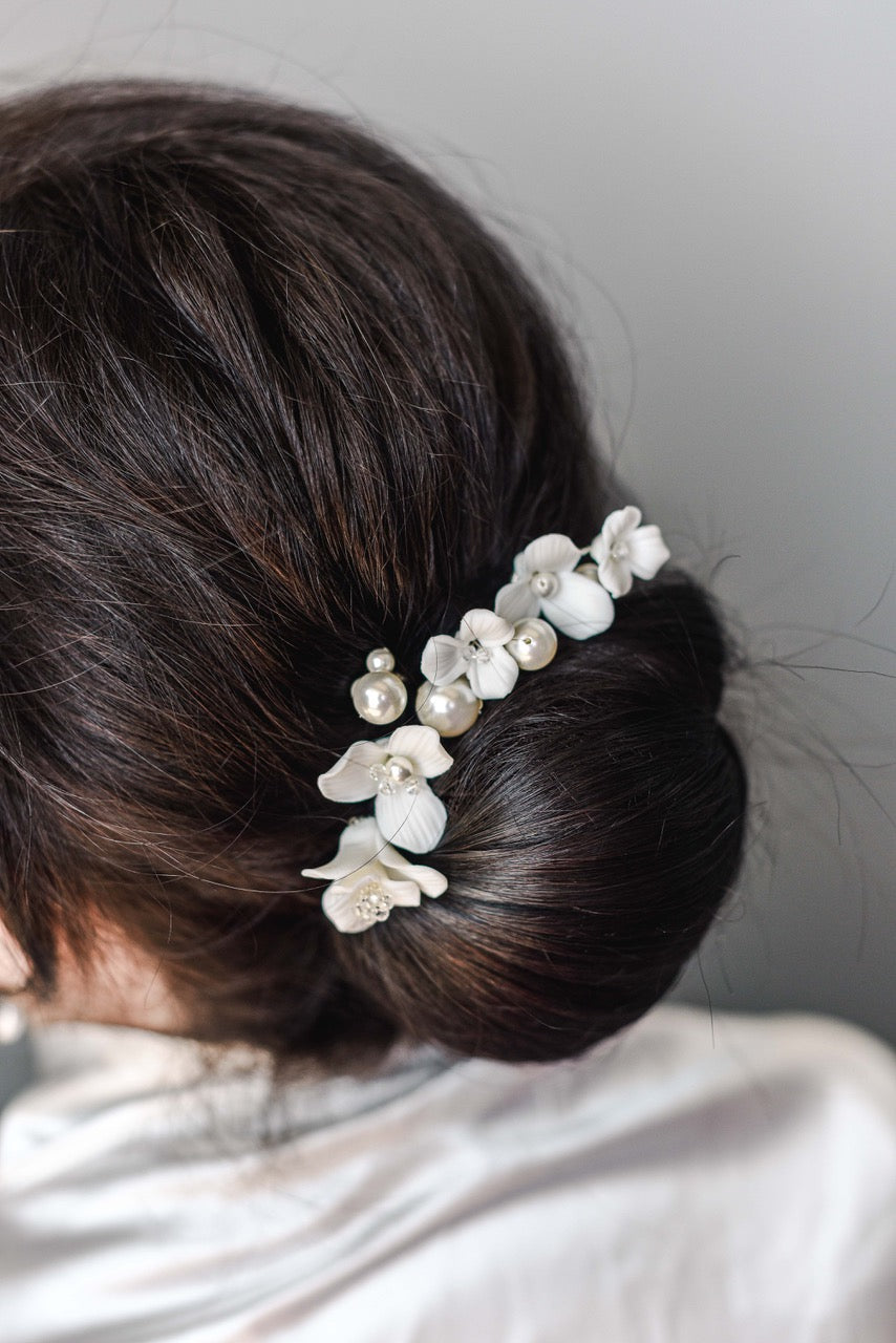 Bride wearing porcelain flower and pearl hair pins in updo