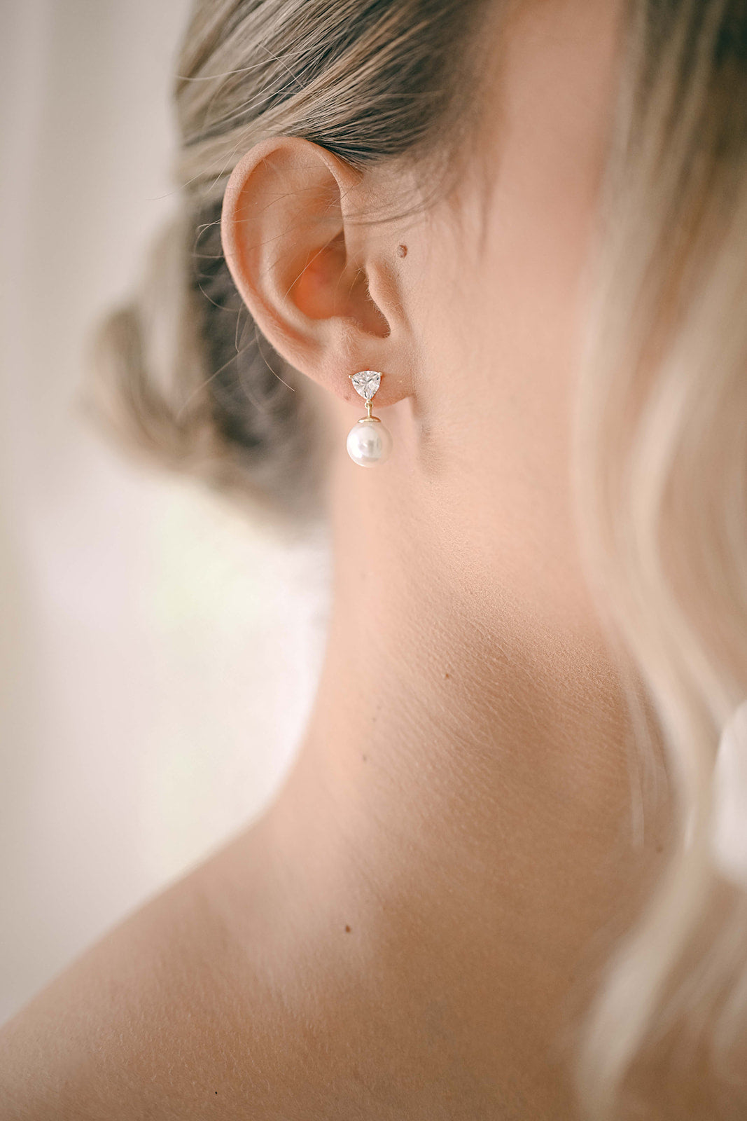 Bride wearing a sterling silver gold plated cubic zirconia earring with a drop pearl