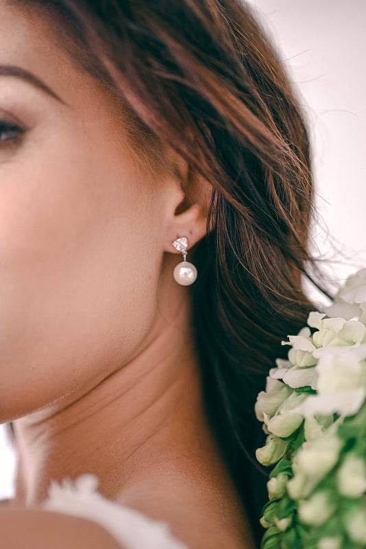 Bride wearing a sterling silver cubic zirconia earring with a drop pearl