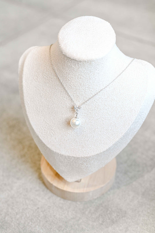 Bride wearing sterling silver, necklace with a triangle cubic zirconia and pearl detail.