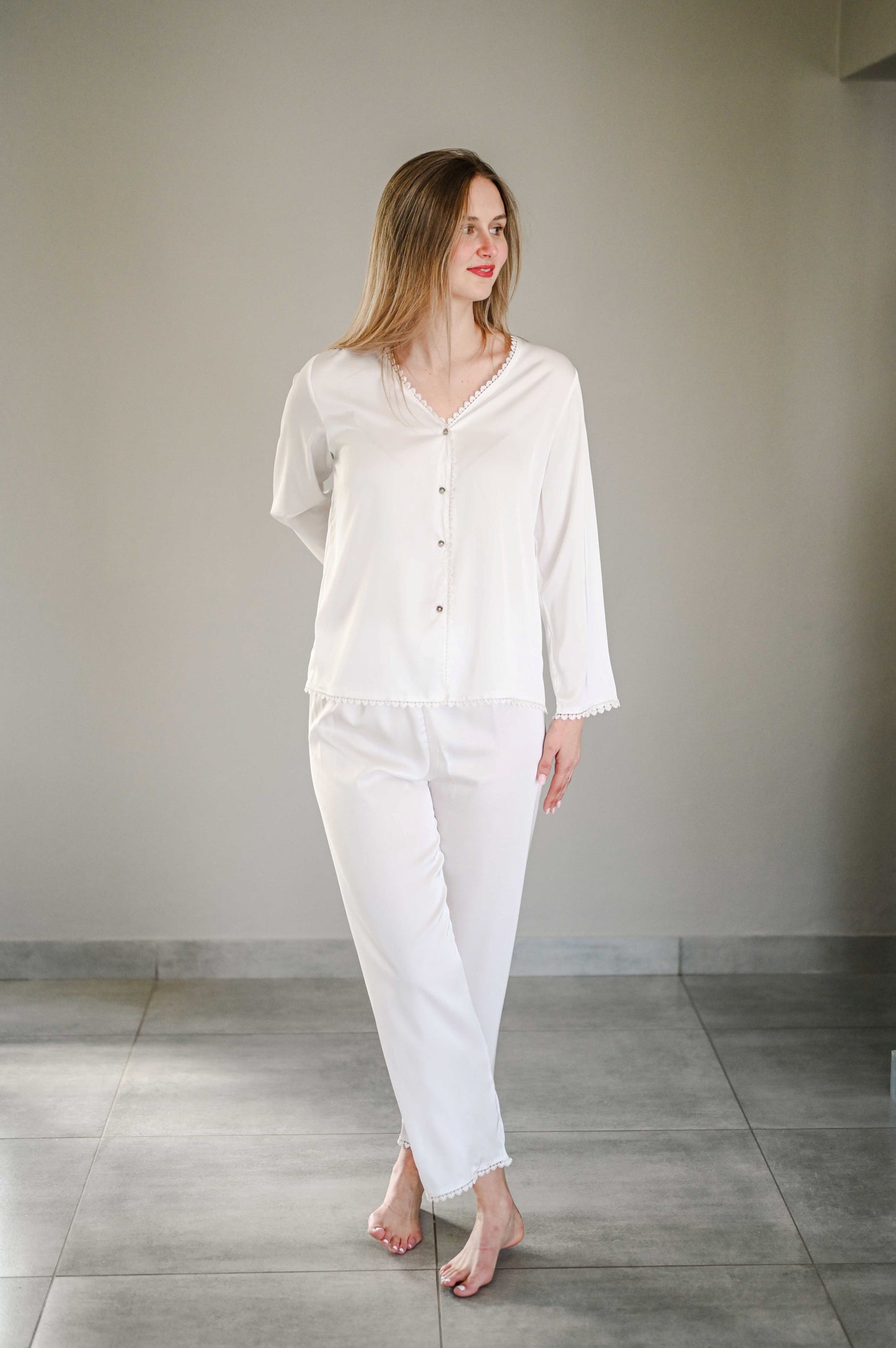 Bride wearing a long sleeve silk pajama set with heart detail on trim.
