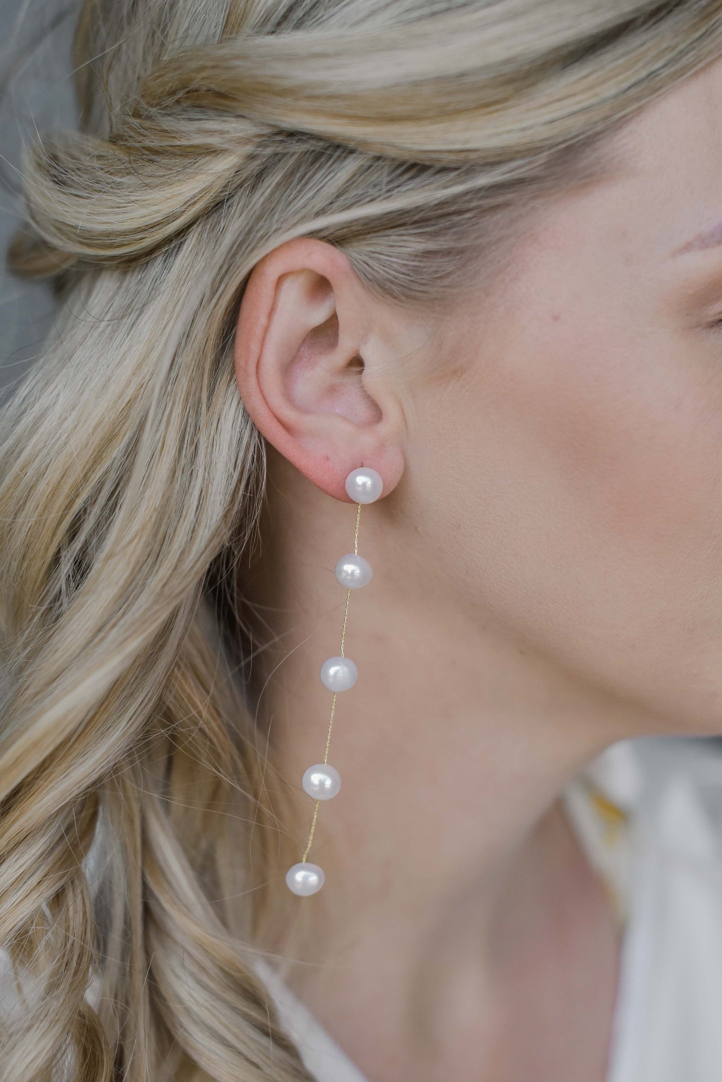 Bride wearing string of 5 fresh water pearls earring