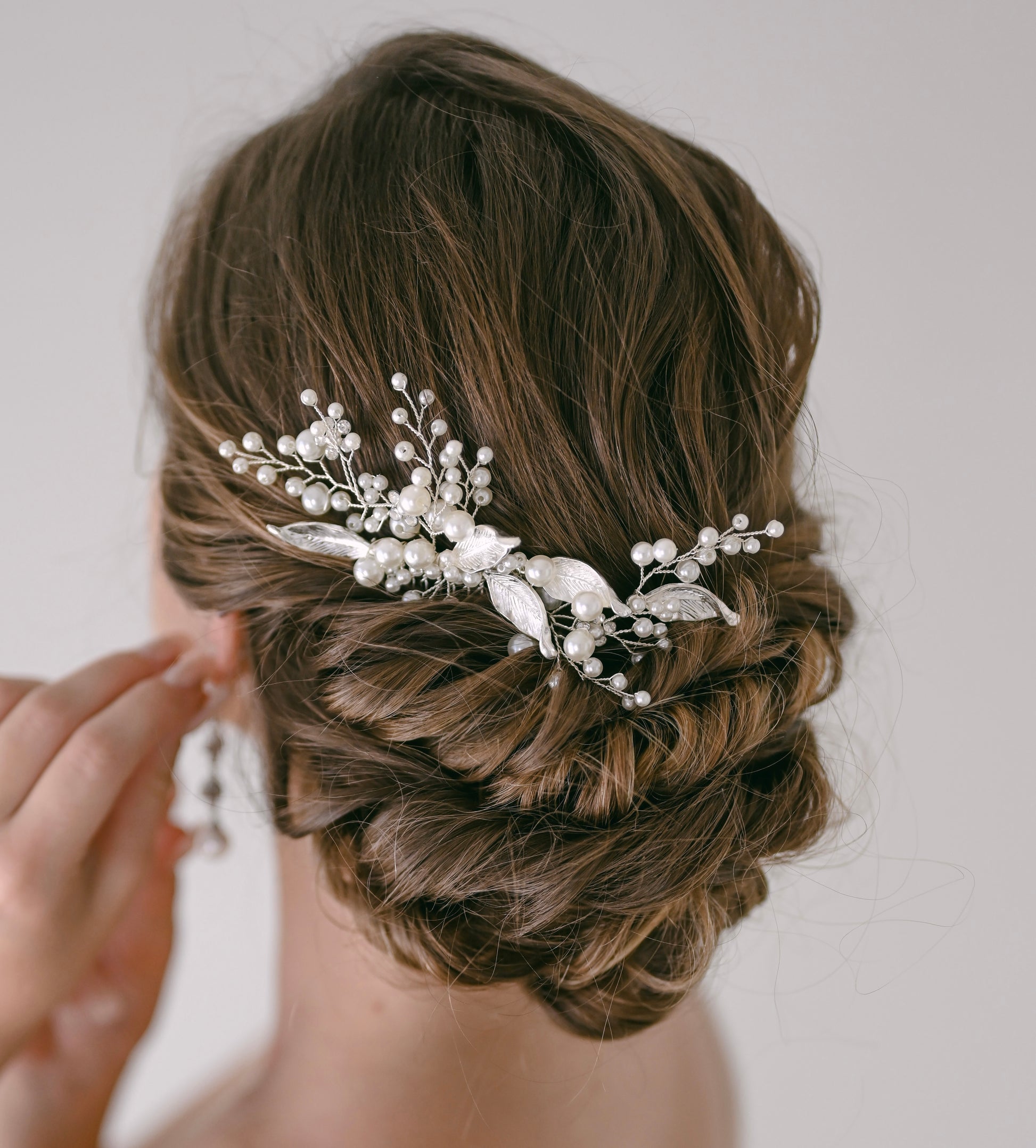 Bride wearing silver pearl and leaf hair comb