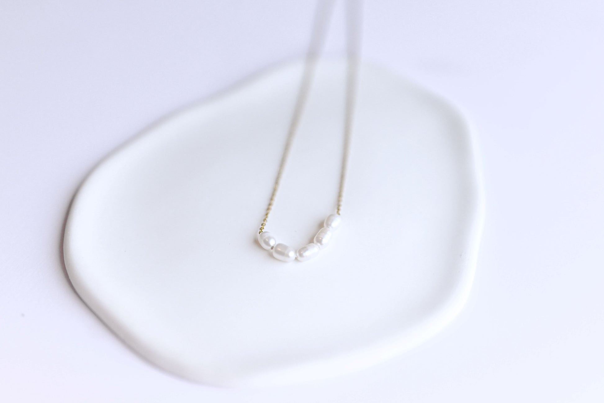 Stainless steel, 18K Gold plated necklace with 5 freshwater pearls.