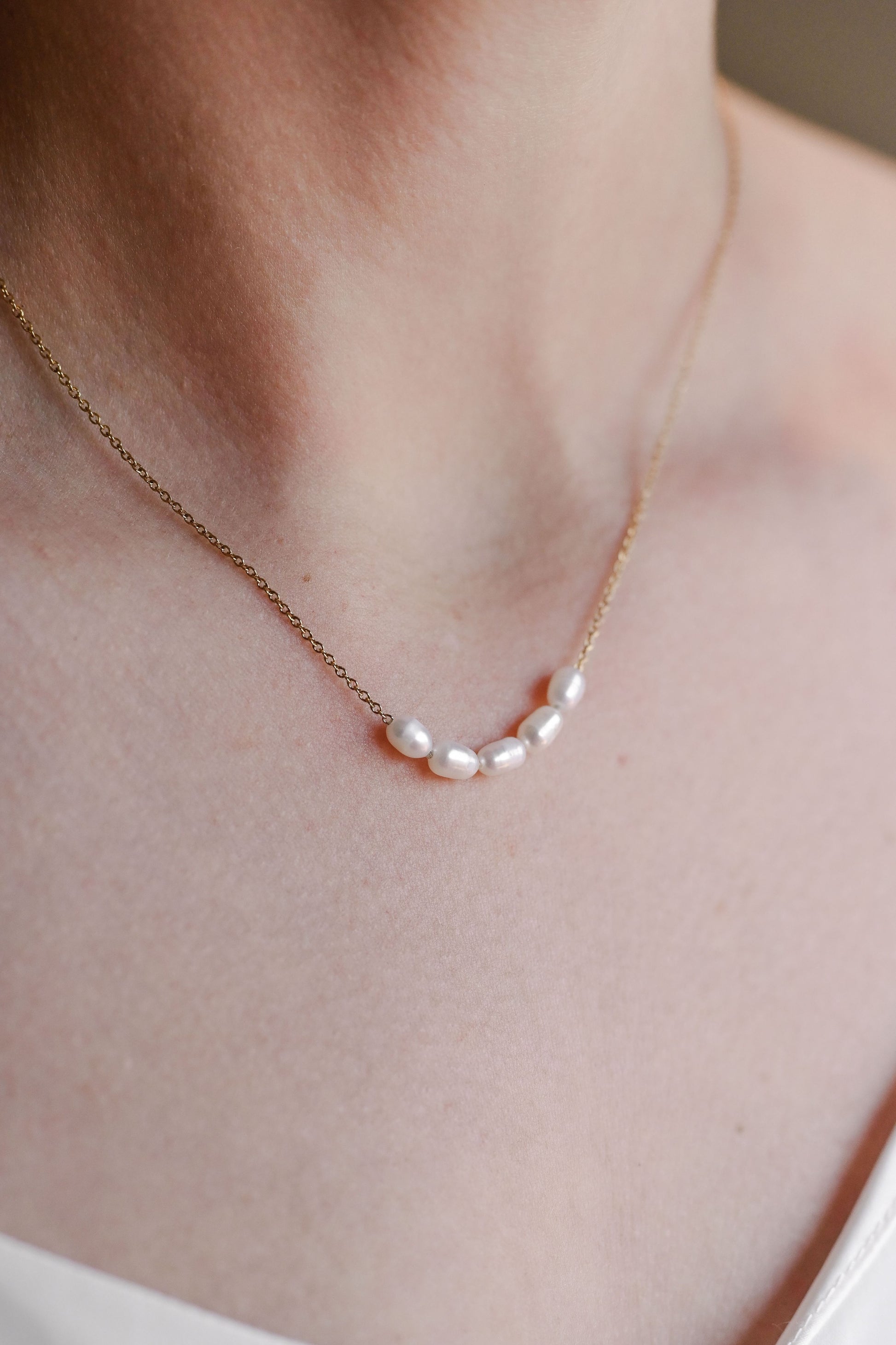 Bride wearing stainless steel, 18K Gold plated necklace with 5 freshwater pearls.