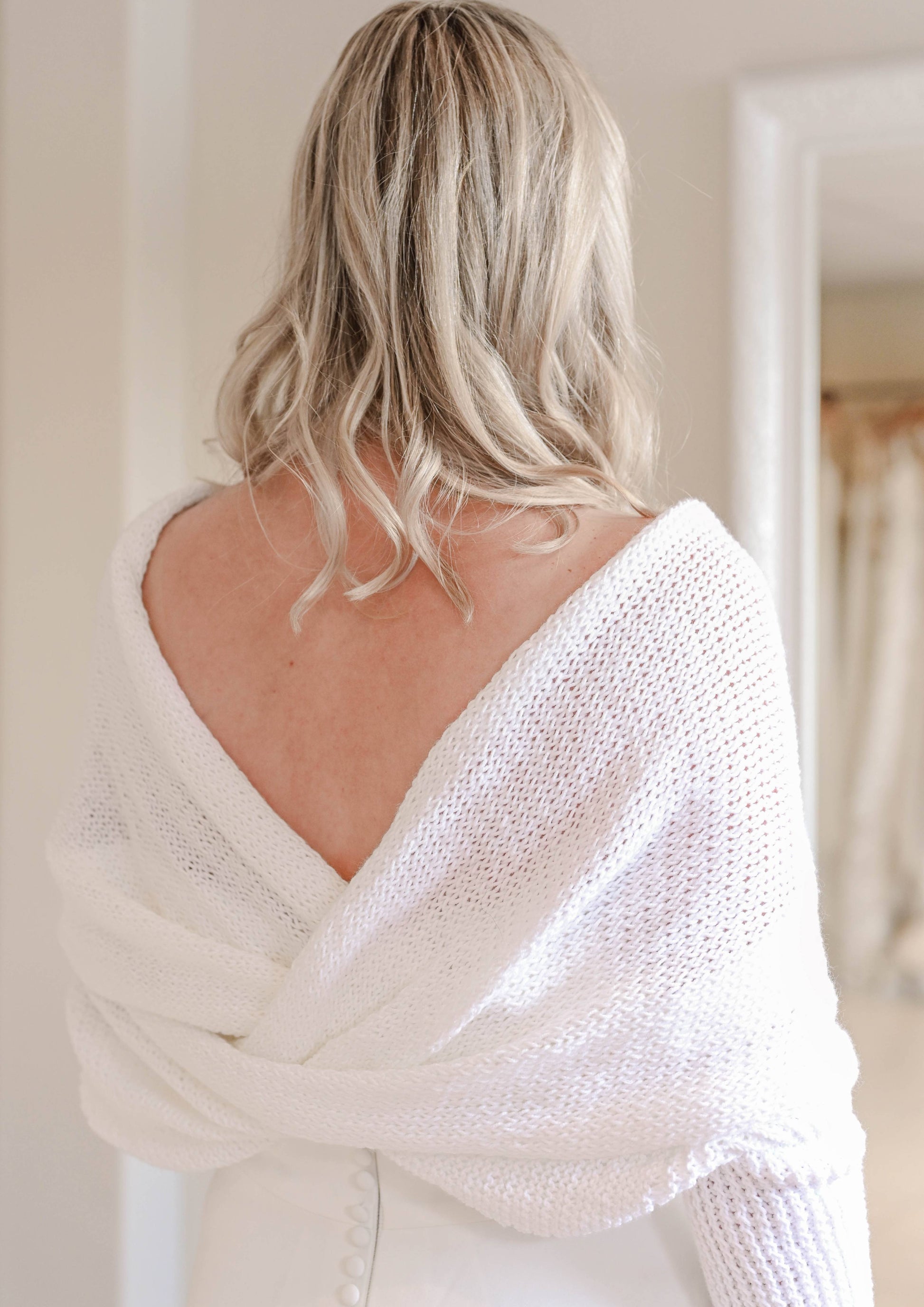 Hand knitted bridal shawl worn over a wedding dress in winter