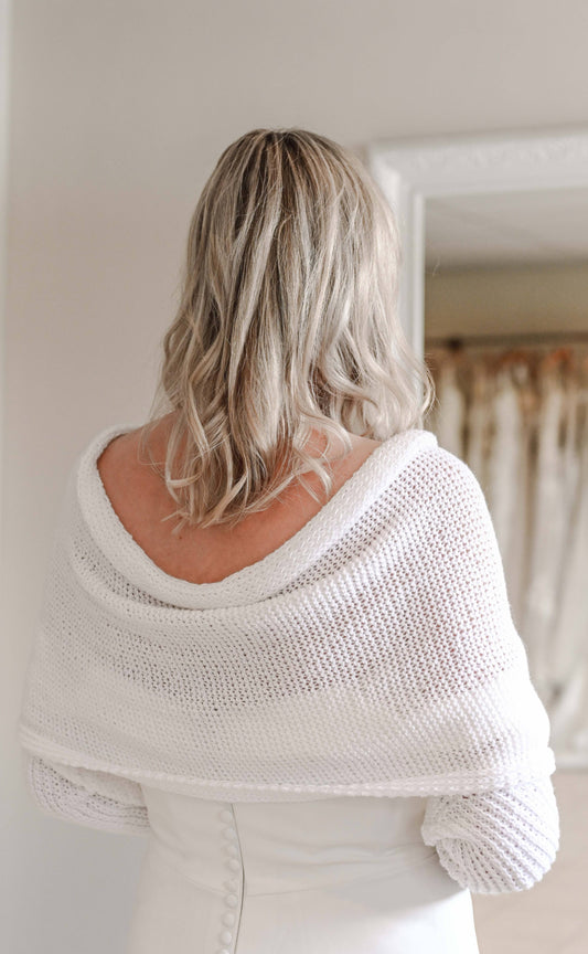 Hand knitted bridal shawl worn over a wedding dress in winter