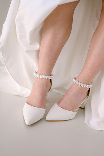 Bride wearing ivory closed toe block heel with pearl ankle strap
