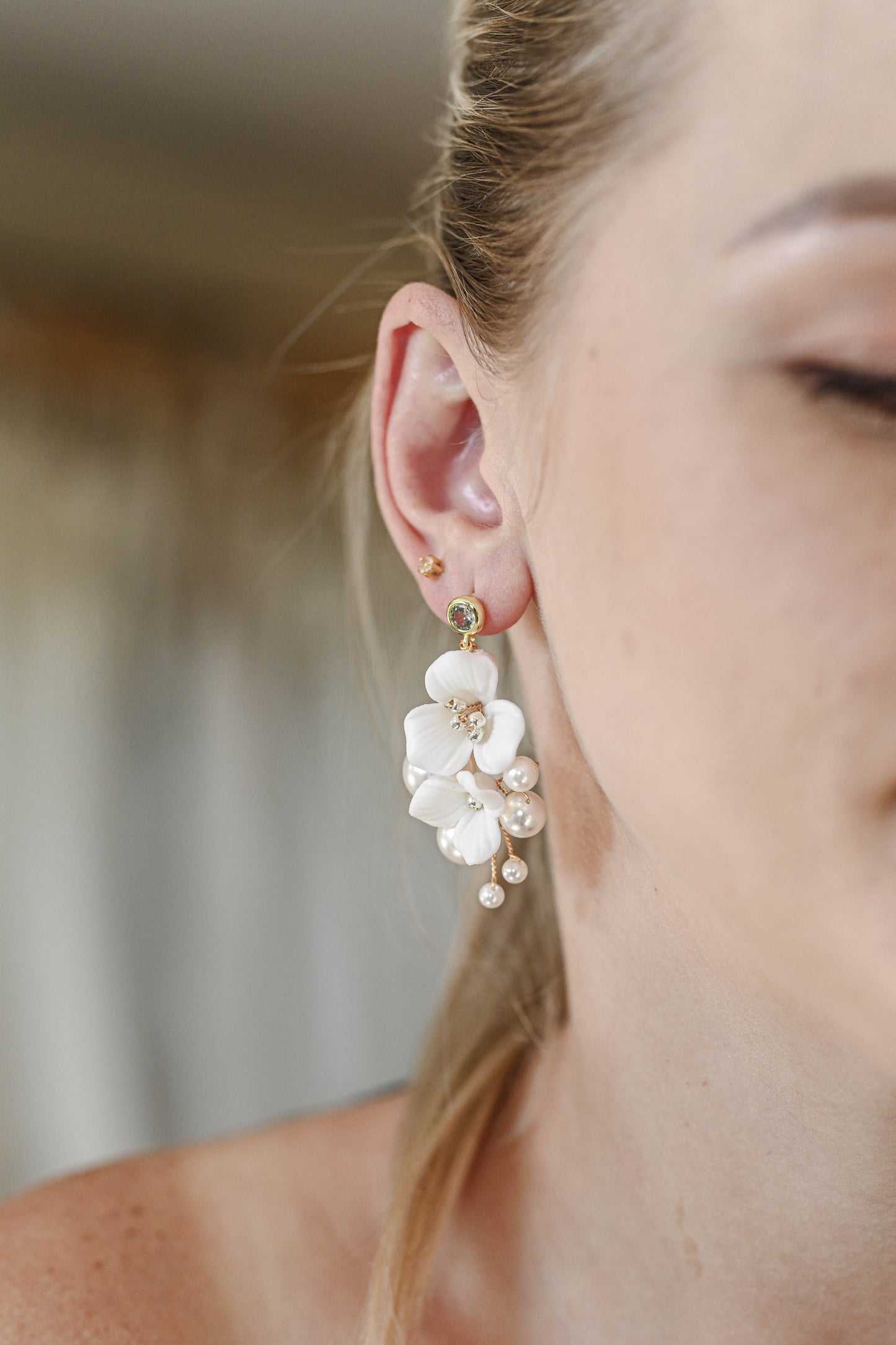 Bride wearing earring with porcelain flowers and pearls