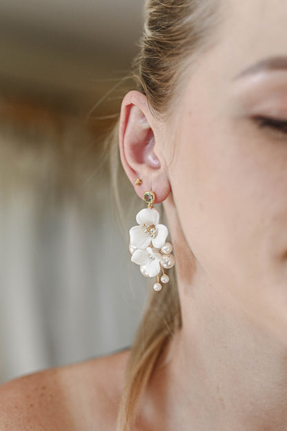 Bride wearing earring with porcelain flowers and pearls