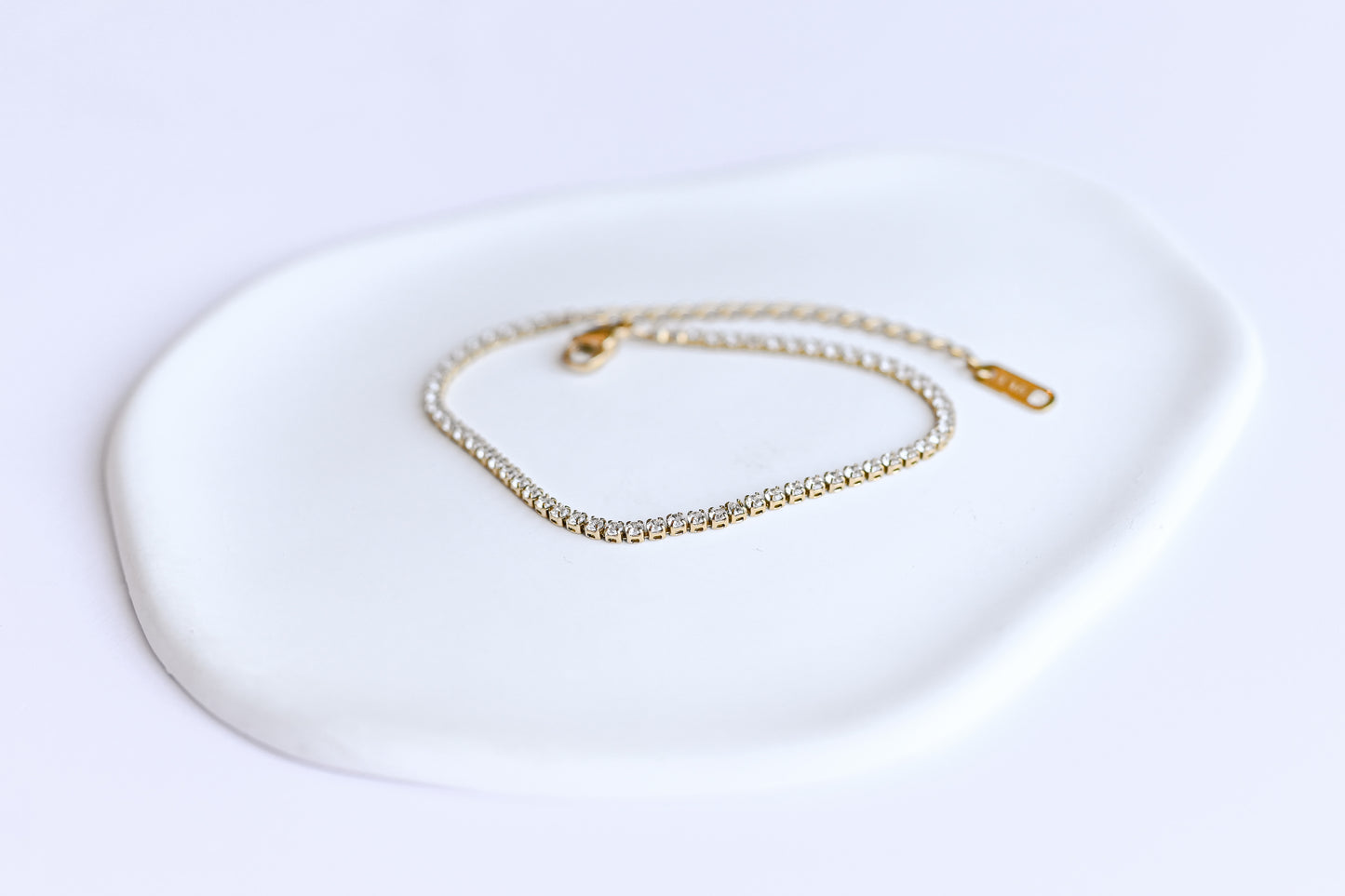 Dainty stainless steel gold plated tennis bracelet with 2mm cubic zirconia.