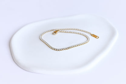 Dainty stainless steel gold plated tennis bracelet with 2mm cubic zirconia.