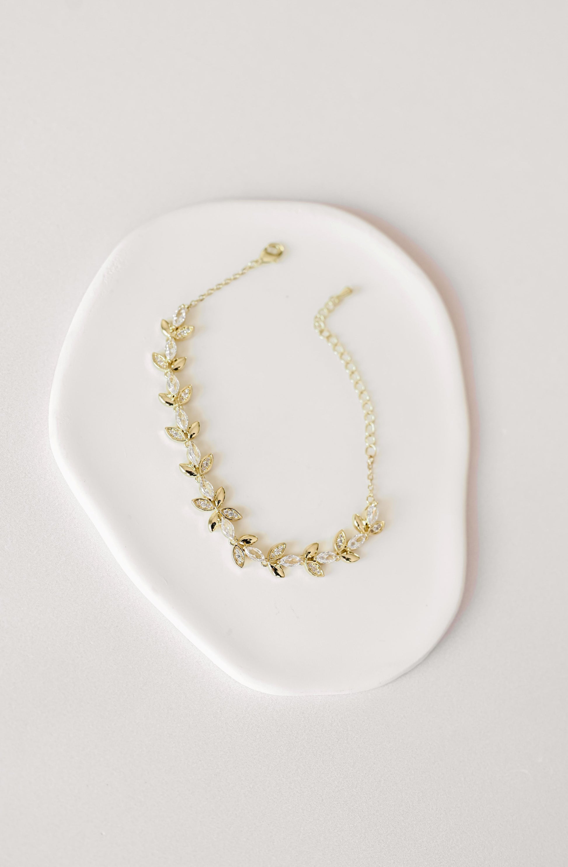 Gold bridal bracelet with cubic zirconia leaf design.