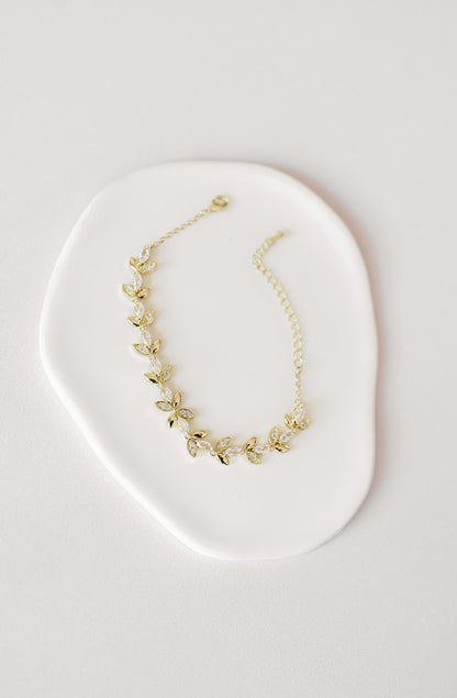Gold bridal bracelet with cubic zirconia leaf design.