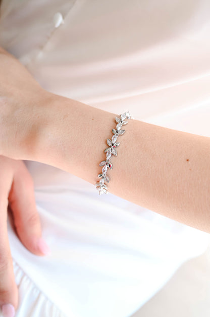Bride wearing a silver bracelet with cubic zirconia leaf design.
