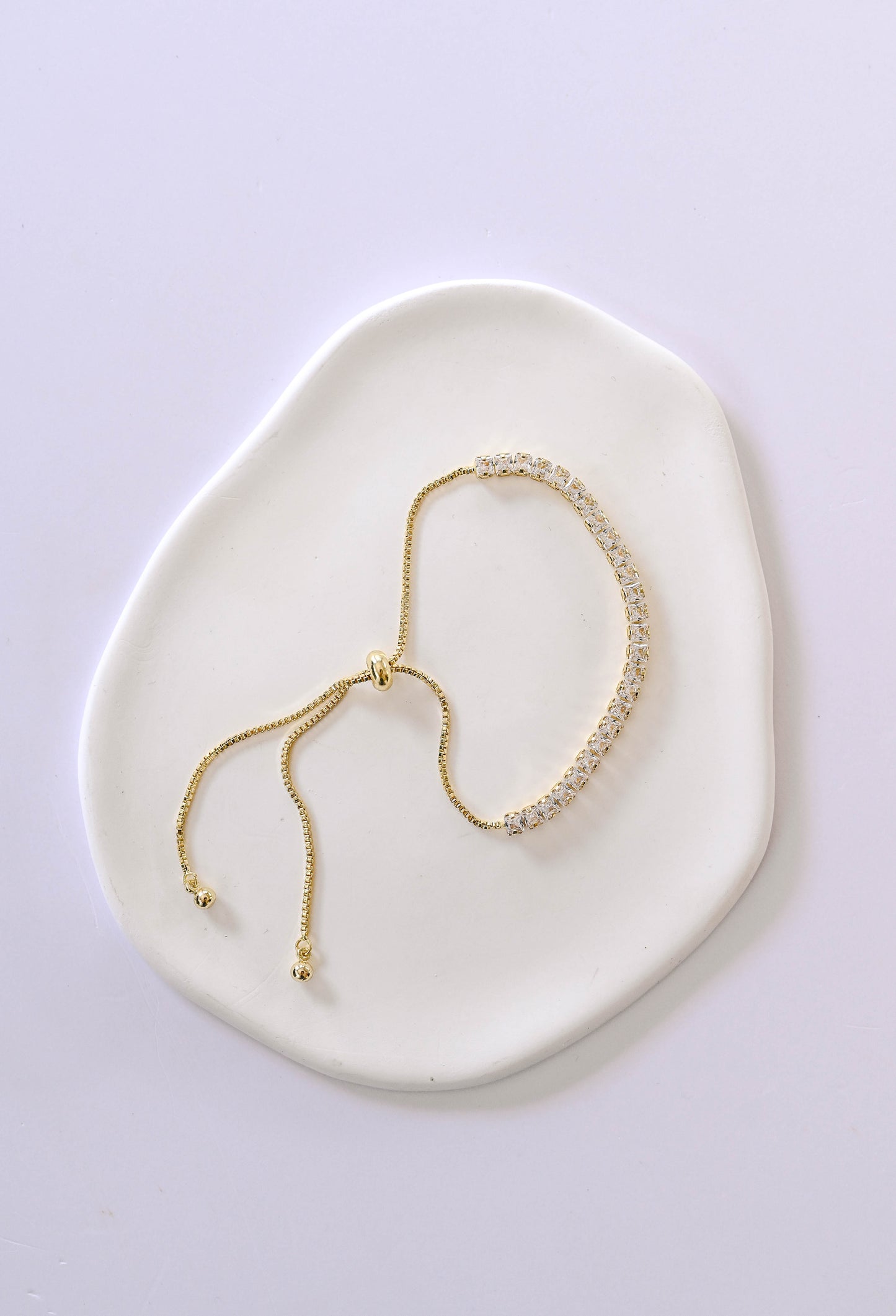 A delicate gold adjustable slide bracelet with cubic zirconia.