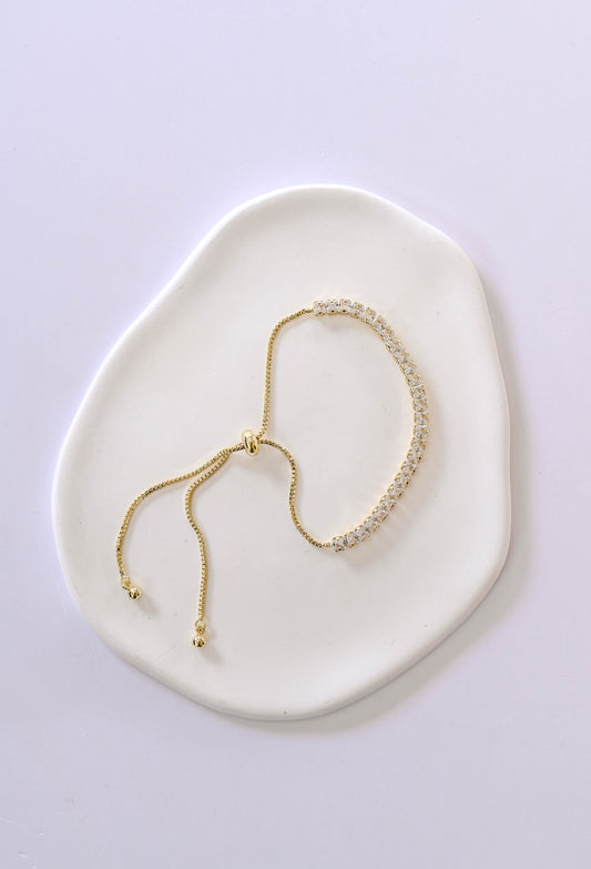 A delicate gold adjustable slide bracelet with cubic zirconia.