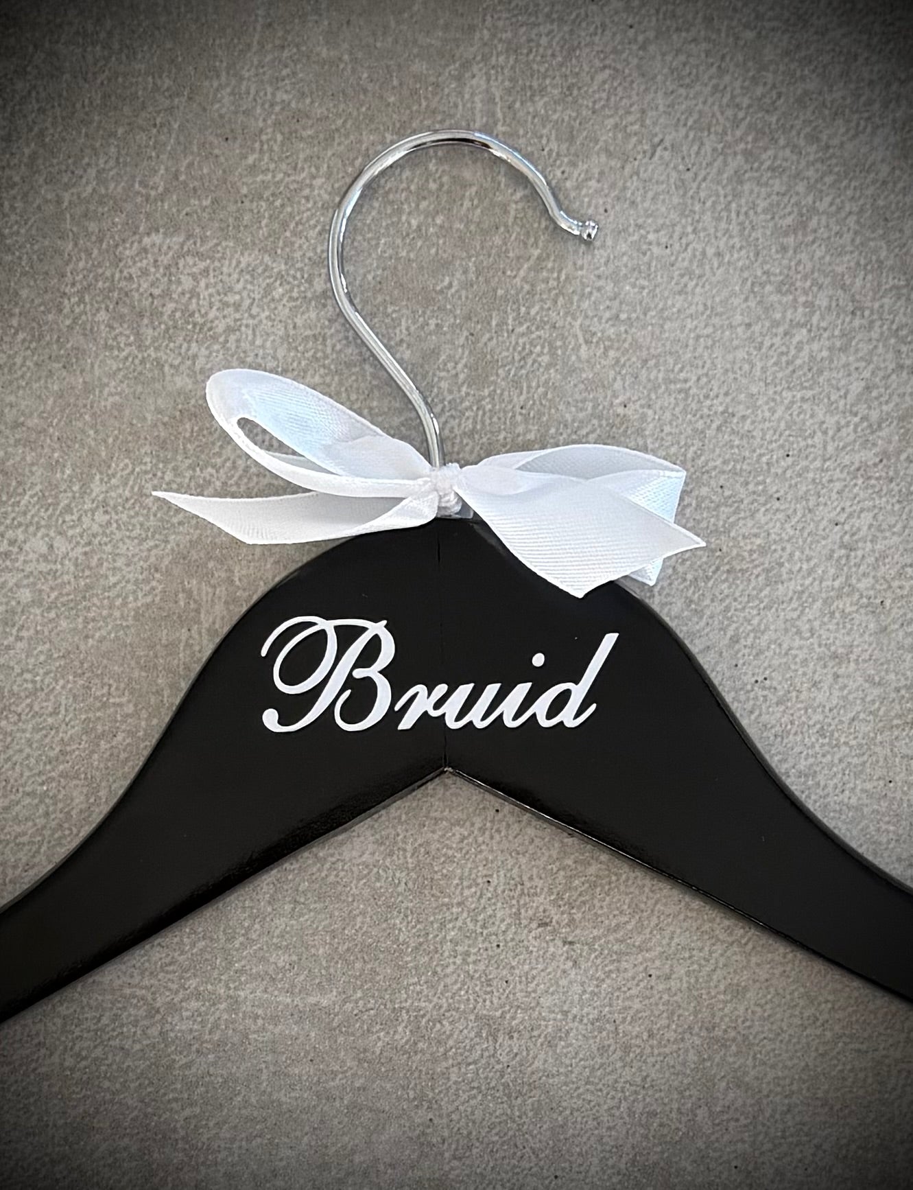 Black wooden hanger with rose white Bruid vinyl and a black ribbon bow
