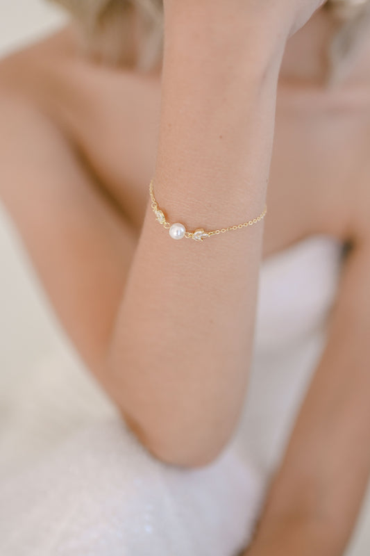 Bride wearing gold adjustable  bracelet with one pearl and cubic zirconia