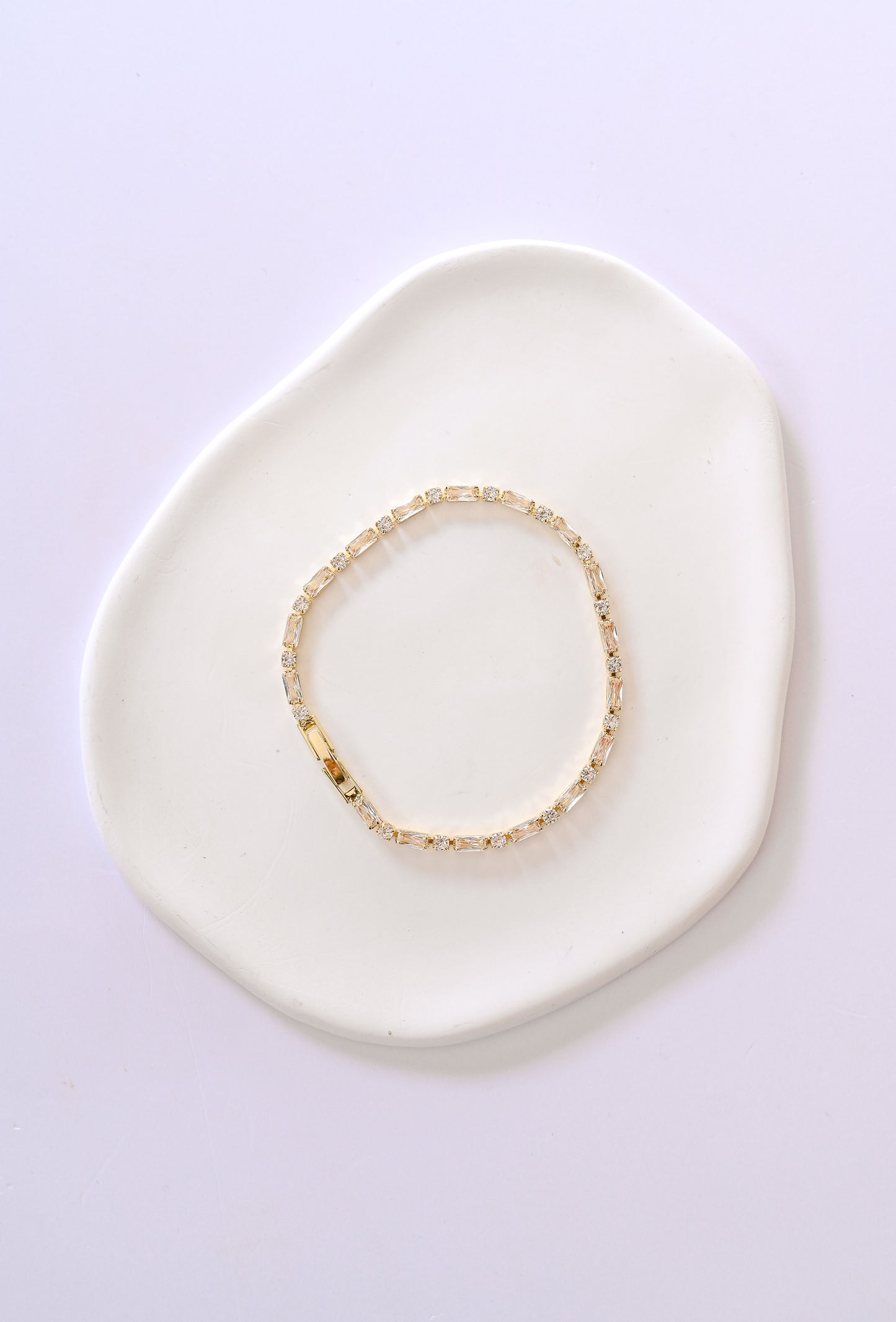 Delicate gold bridal bracelet with baguette and square shaped cubic zirconia.