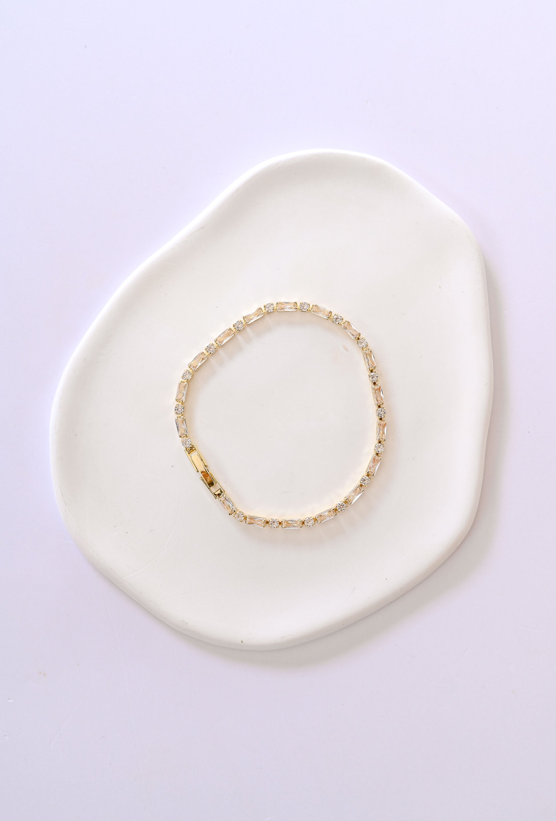 Delicate gold bridal bracelet with baguette and square shaped cubic zirconia.
