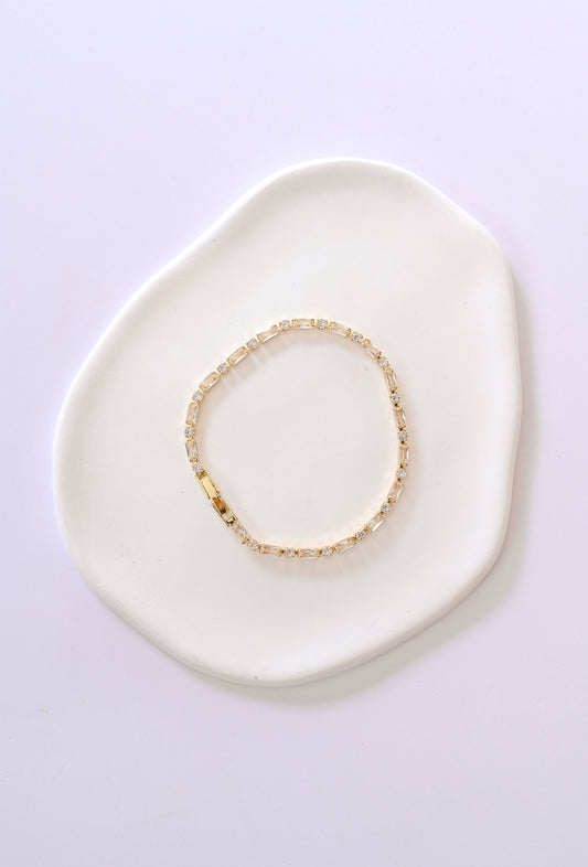 Delicate gold bridal bracelet with baguette and square shaped cubic zirconia.