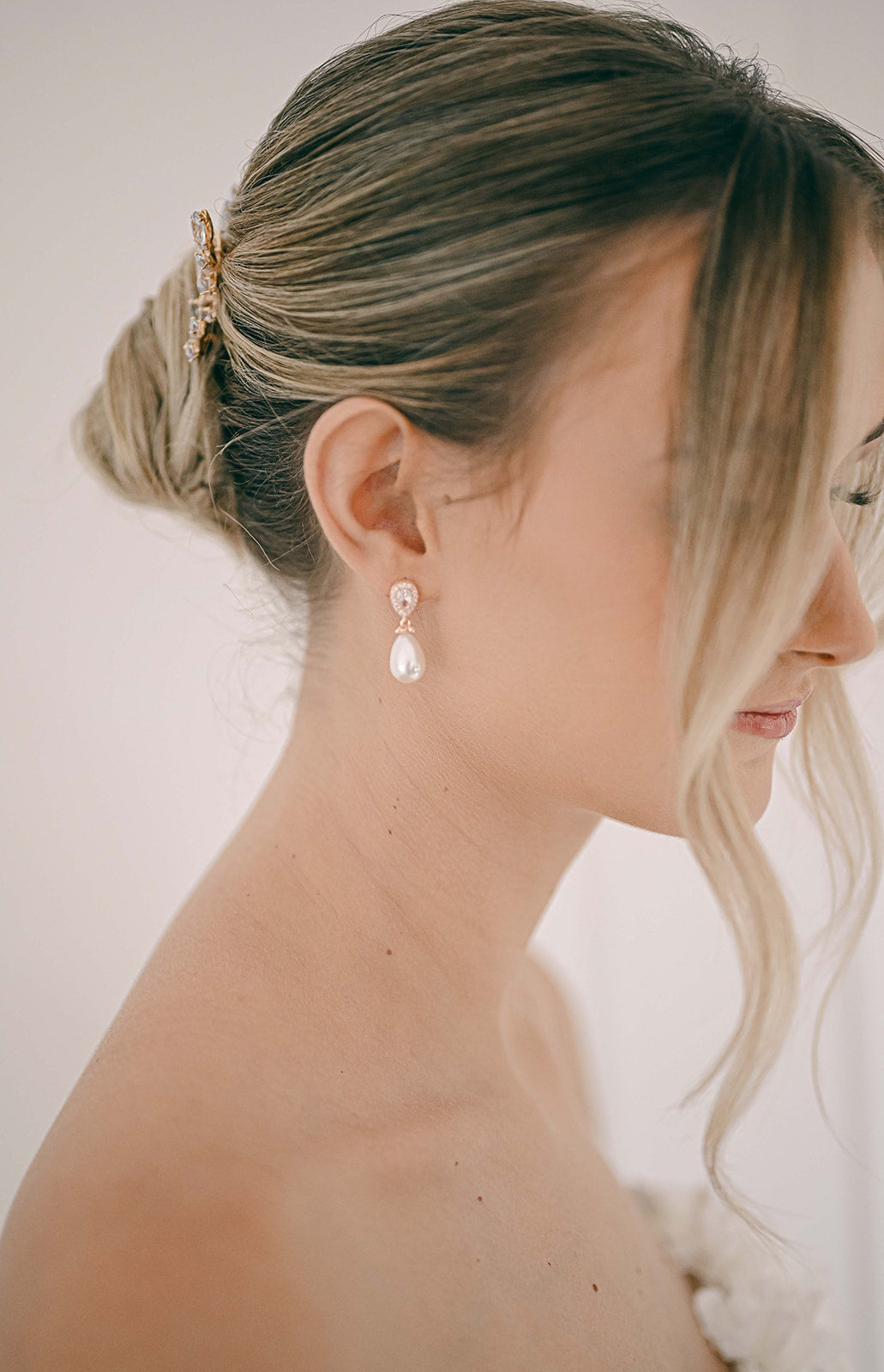 Bride wearing rose gold earring with cubic zirconia and teardrop pearl