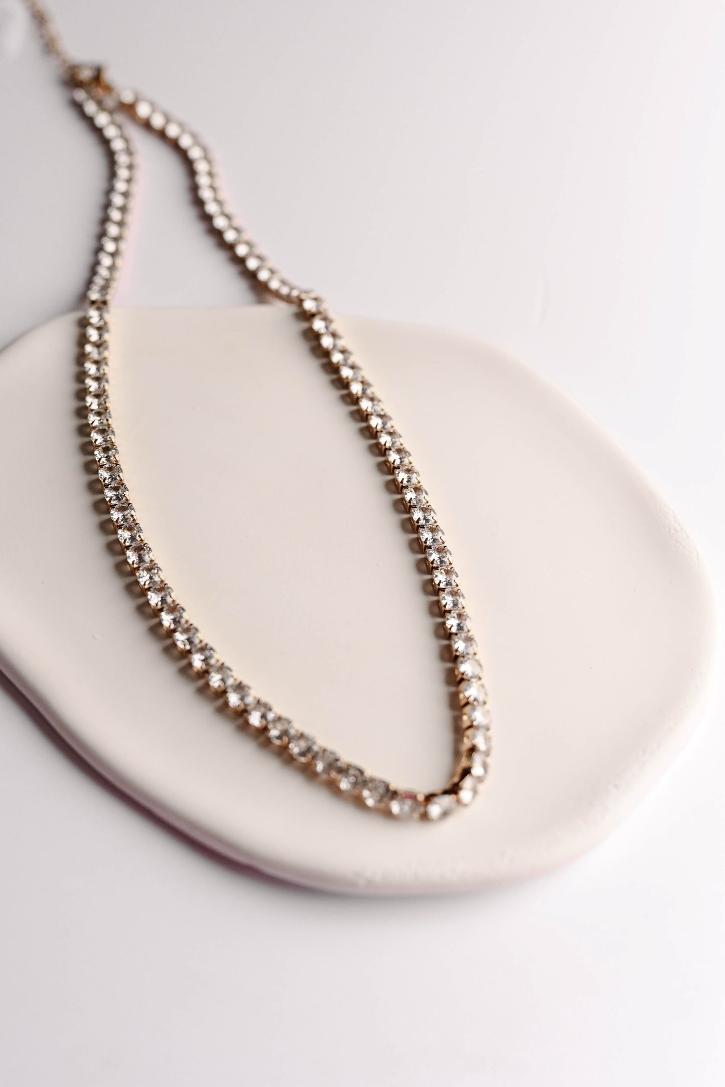 Stainless steel, 18K gold PVD plated necklace with 4mm cubic zirconia. Water and tarnish proof.