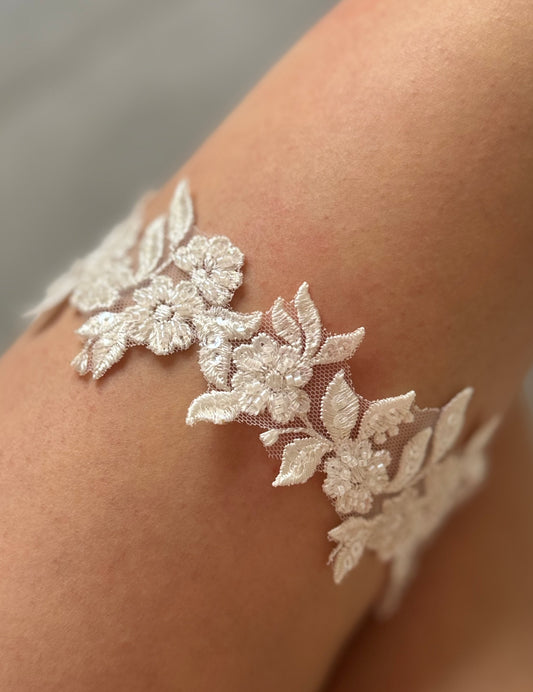 Floral beaded lace garter on bride