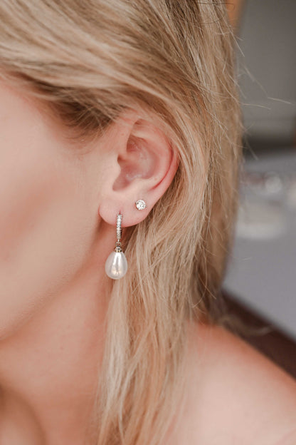 Bride wearing silver hoop earring with cubic zirconia and a faux pearl