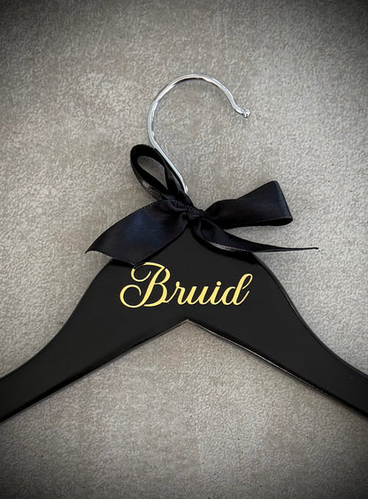 Black wooden hanger with gold Bruid vinyl and a white ribbon bow