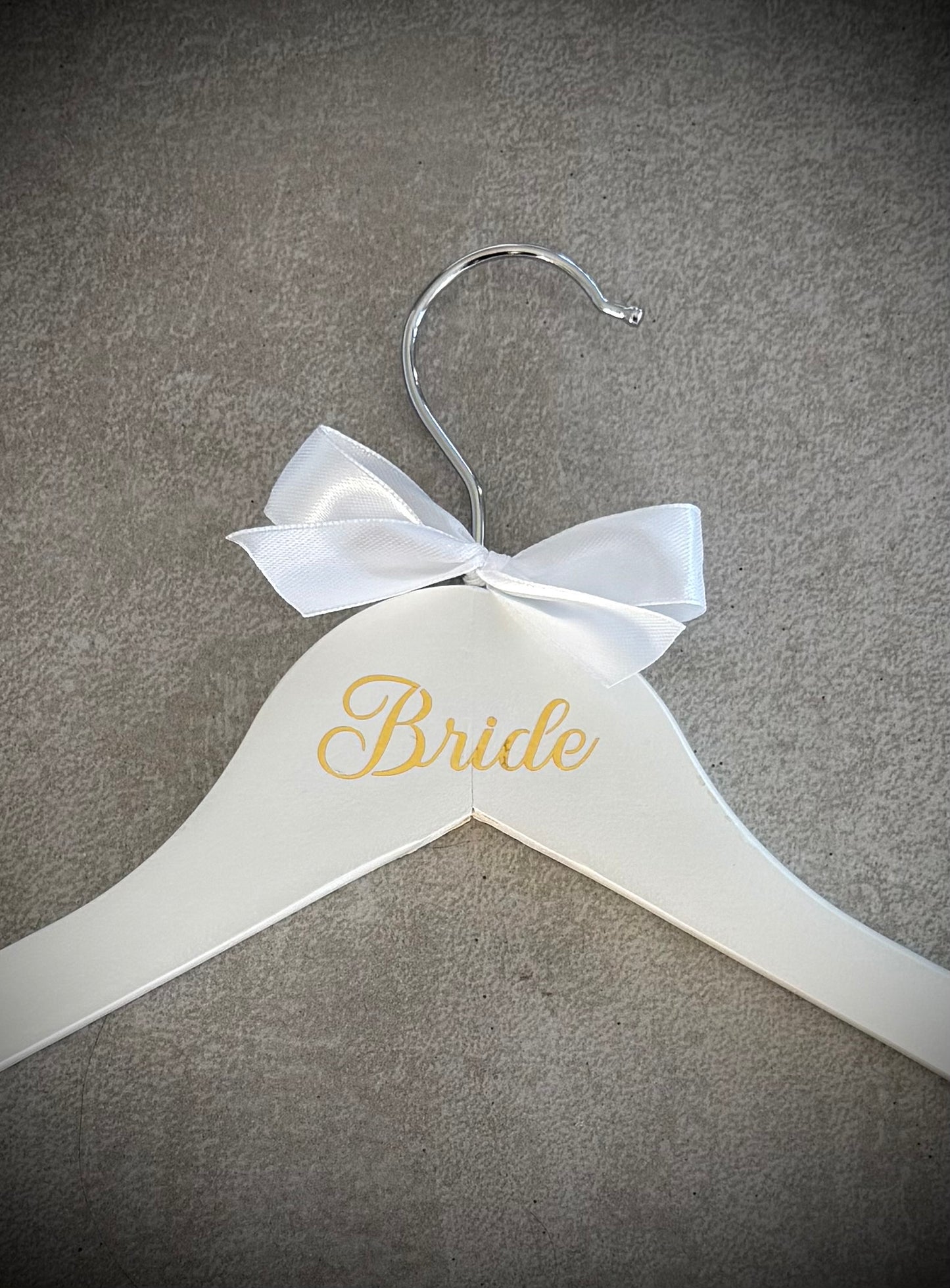 White wooden hanger with gold Bride vinyl and a white ribbon bow