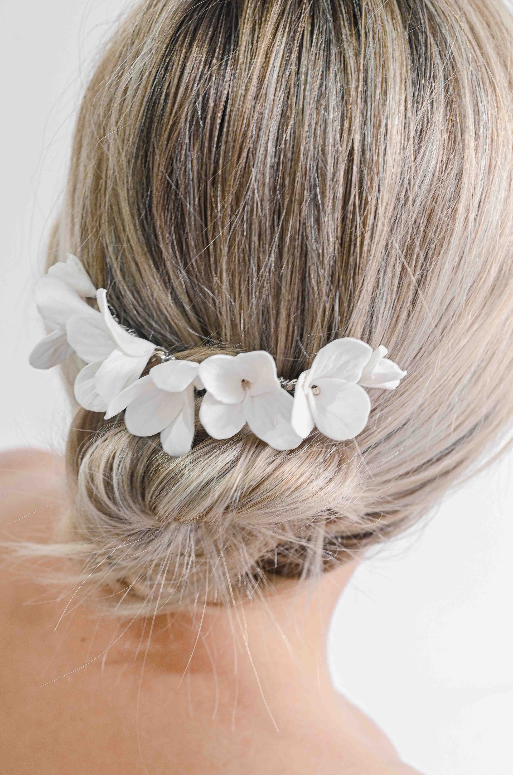 Bride wearing a bridal hair comb with handmade clay flowers 
