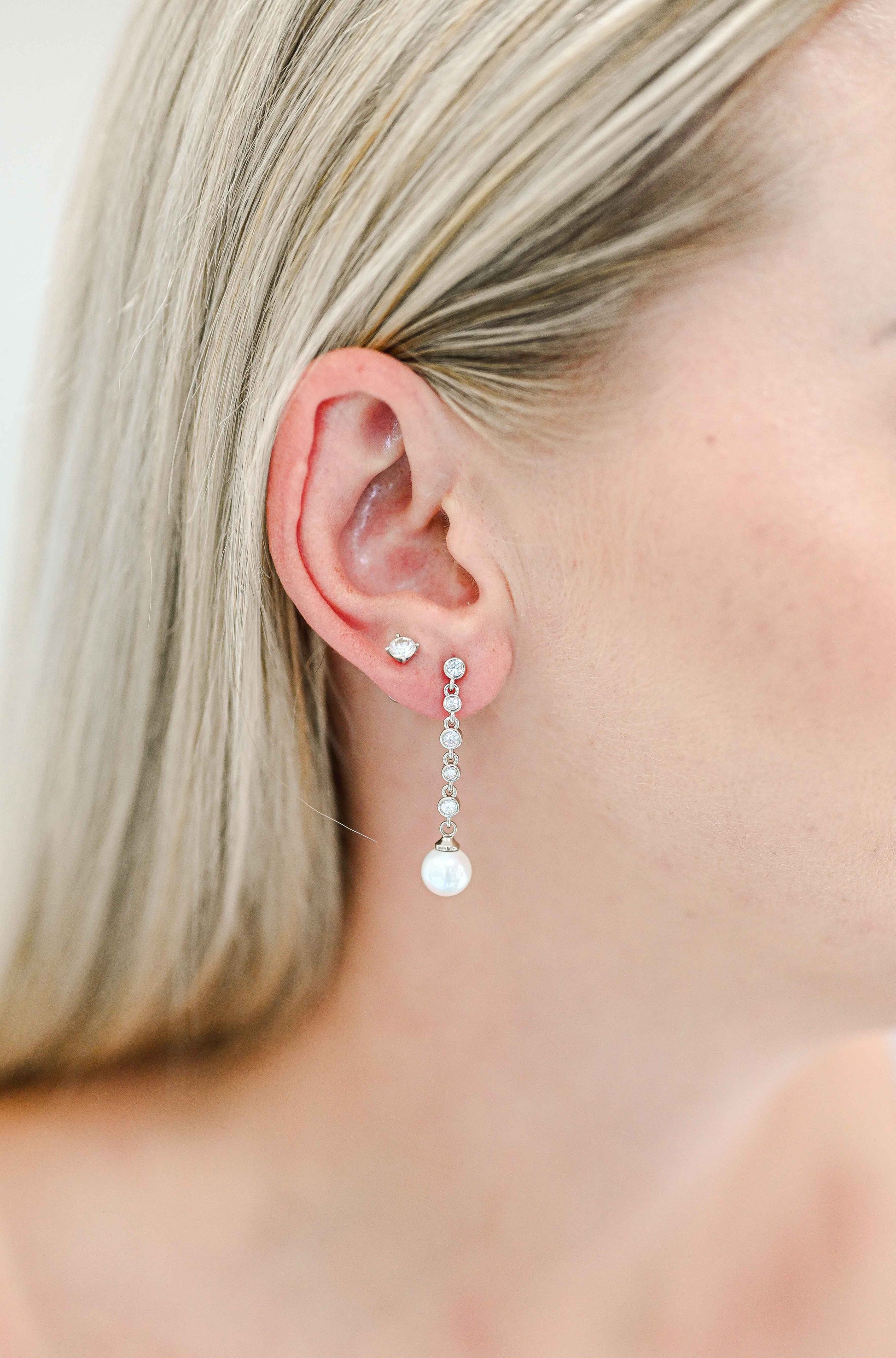 Bride wearing a dainty cubic zirconia drop earring with a faux pearl