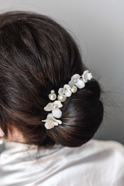 Bride wearing  porcelain flower and pearl hair pins in updo