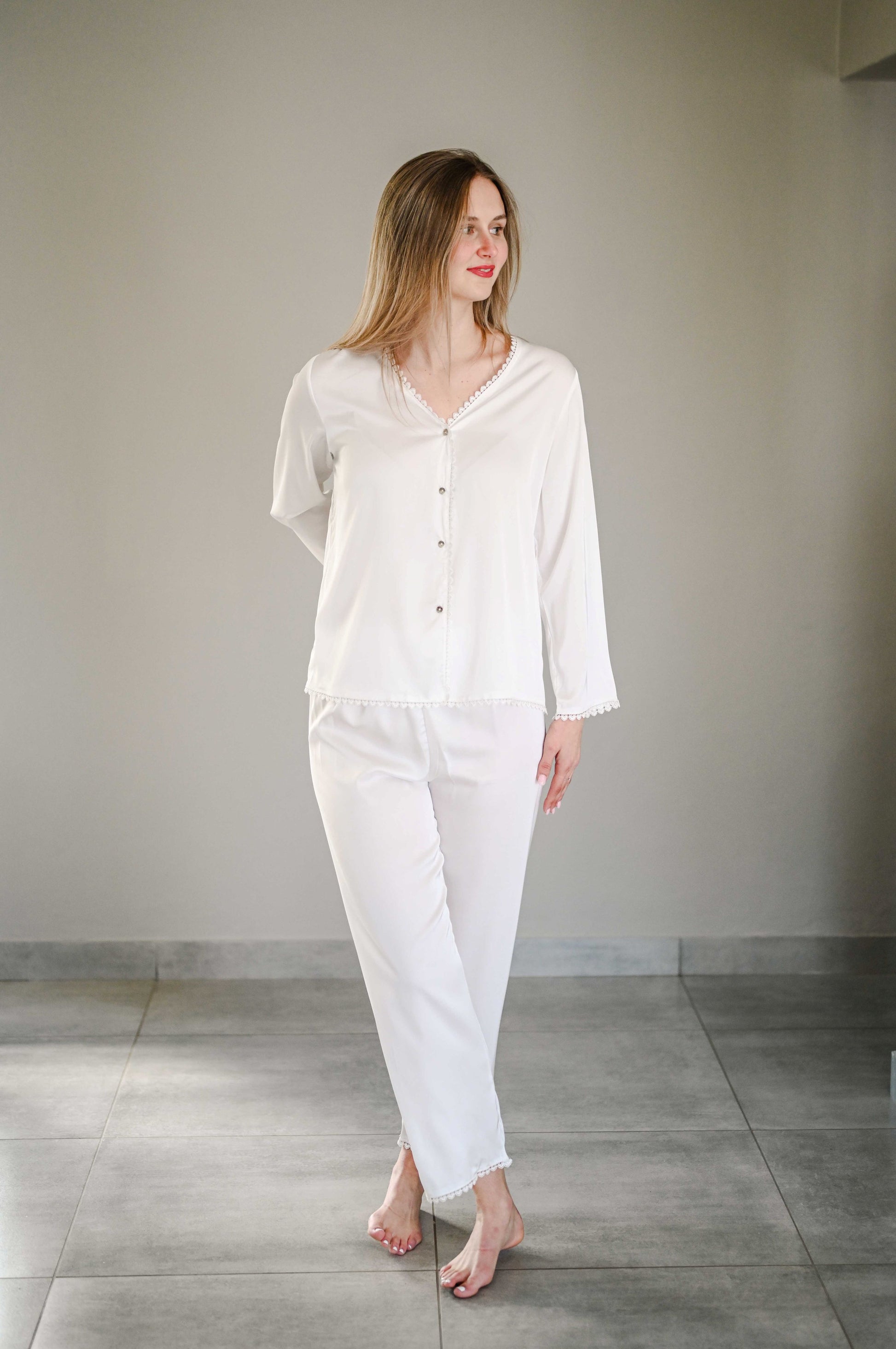 Bride wearing a long sleeve silk pajama set with heart detail on trim.